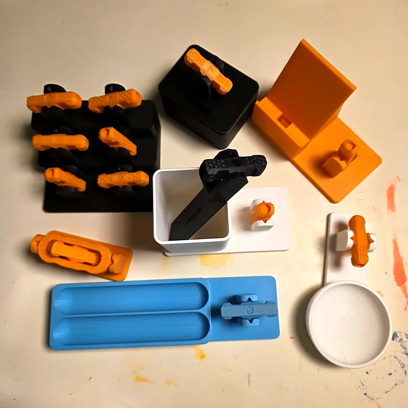 Flat lay of printed accessories: rotor shelf, pen tray, phone stand, cup and holders